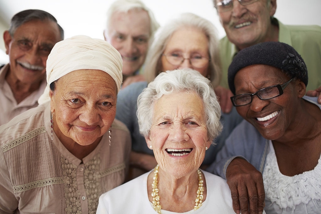 A group of seniors smiling together while in a retirement home
